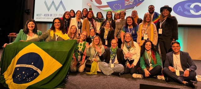 Grupo de pessoas segurando a bandeira do Brasil em um evento internacional