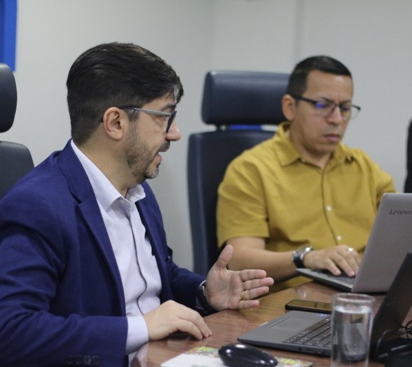 Dois homens em uma mesa de reunião.