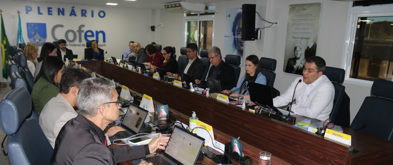 Homens e mulheres sentados ao redor de uma mesa grande de reunião