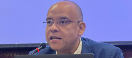 Pessoa sentada falando para o público de um auditório