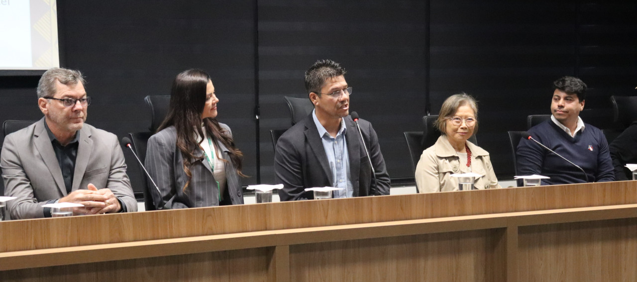 Pessoas sentadas lado a lado num auditório