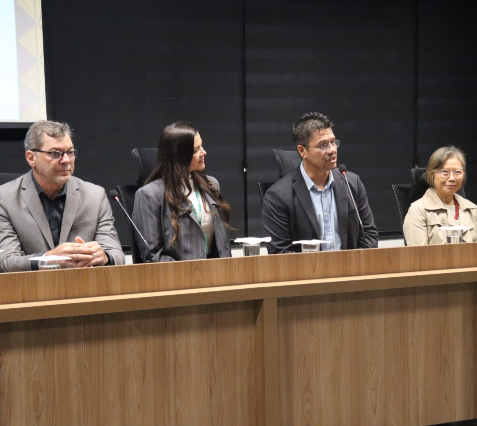 Pessoas sentadas lado a lado num auditório