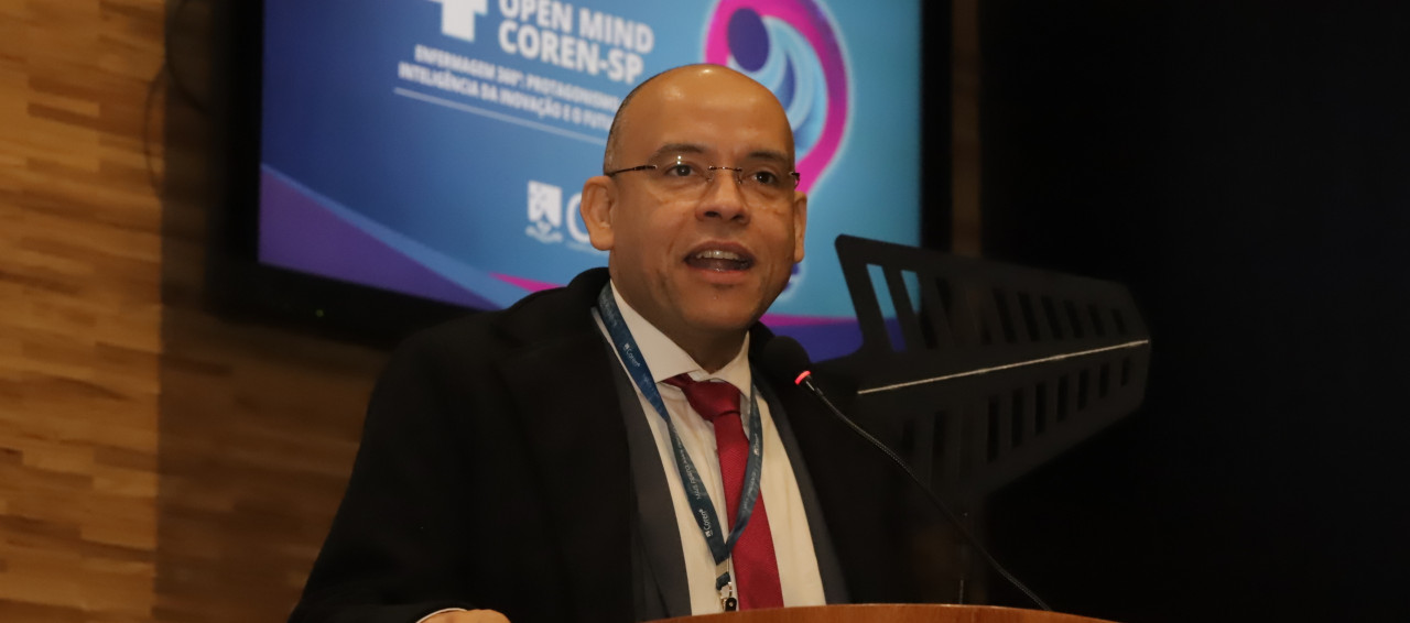 Uma pessoa em pé falando em um auditório