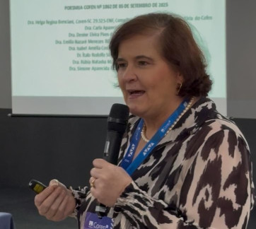 Pessoa em pé lecionando em um curso para profissionais de Enfermagem